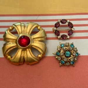 3 unmarked costume pins. Red, blue, purple rhinestones. No missing rhinestones.